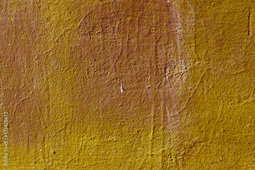 Texture of the lemon yellow stucco wall with scratches, cracks, dust, crevices, roughness. Can be used as a poster or background for design.