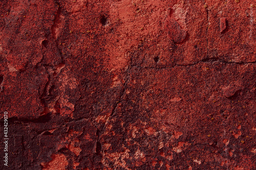 Red textured concrete wall with natural defects. Scratches, cracks, crevices, chips, dust, roughness. 