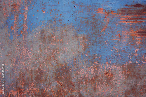 Gray rough background with peeling paint and color streaks. Surface with scratches, chips and colored lines. Fragment of graffiti. The concept of street riots and hooliganism.