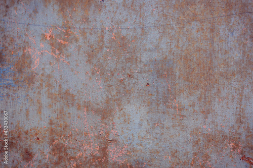 Gray rough background with peeling paint and color streaks. Surface with scratches, chips and colored lines. Elements of corrosion and fading.