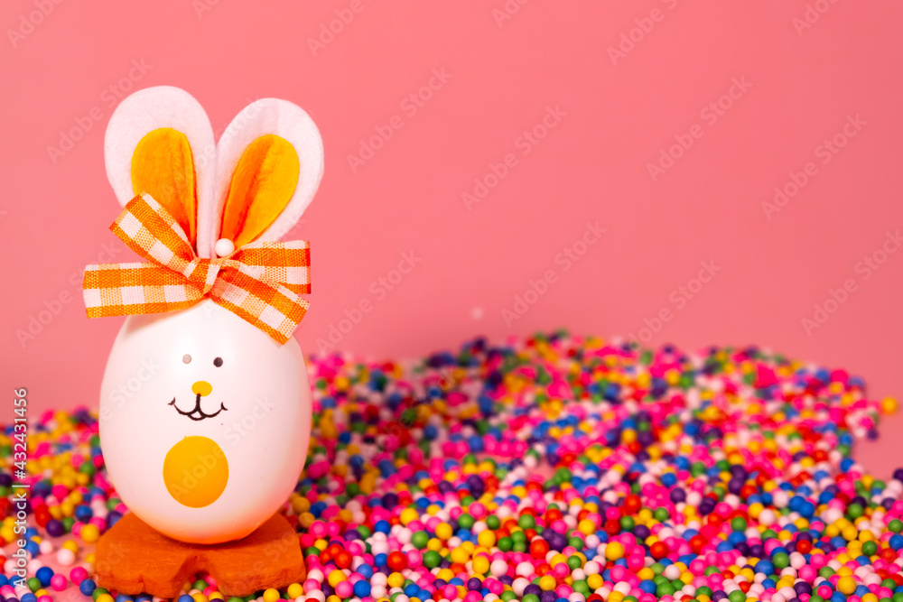 Ideas for holiday decoration. Easter eggs looking like a rabbit. With a painted face. On a light pink background. Copy space. Isolated