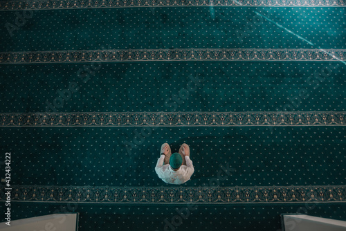 Photography Muslim man praying in mosque and reading Quran