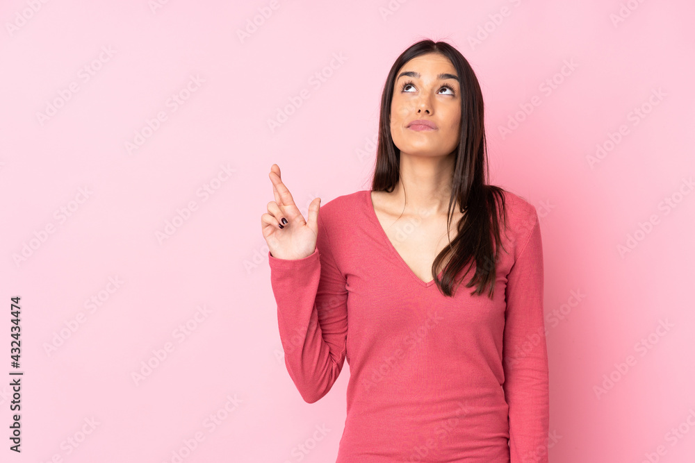 Young caucasian woman over isolated background with fingers crossing and wishing the best Young caucasian woman over isolated background with fingers crossing and wishing the best