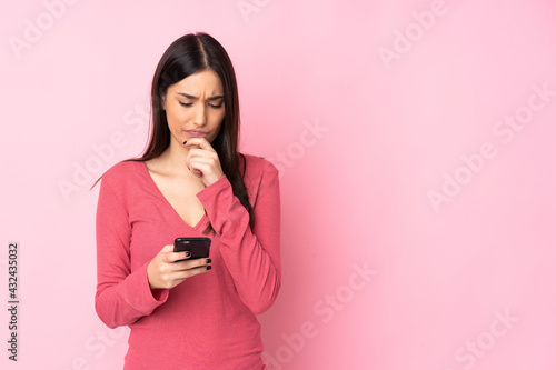 Young caucasian woman over isolated background thinking and sending a message