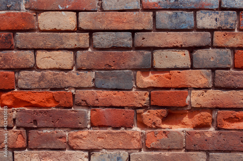 Old shabby wall with elements of destroyed bricks. Dark brick background. Can be used as background for design or poster.