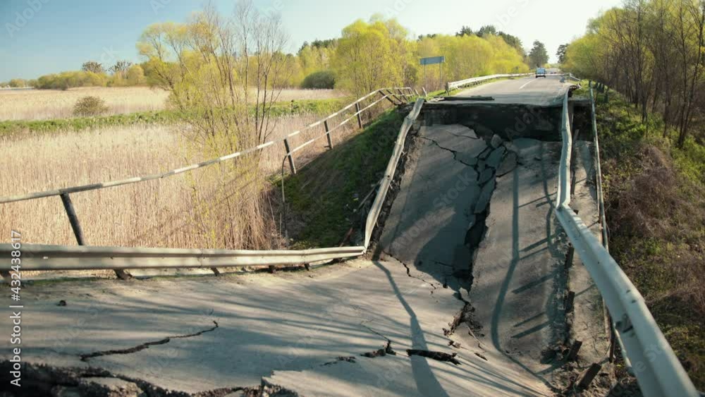 Flood damaged closed highway road, bridge. Cracked asphalt after