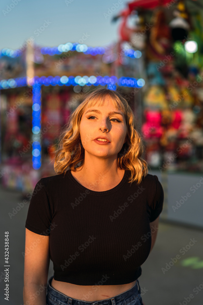 Retrato cercano de chica joven guapa rubia en zona de juegos de una feria Retrato cercano de chica joven guapa rubia en zona de juegos de una feria