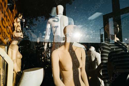Mannequins are seen in a retail storefront display window in the Los Angeles fashion district