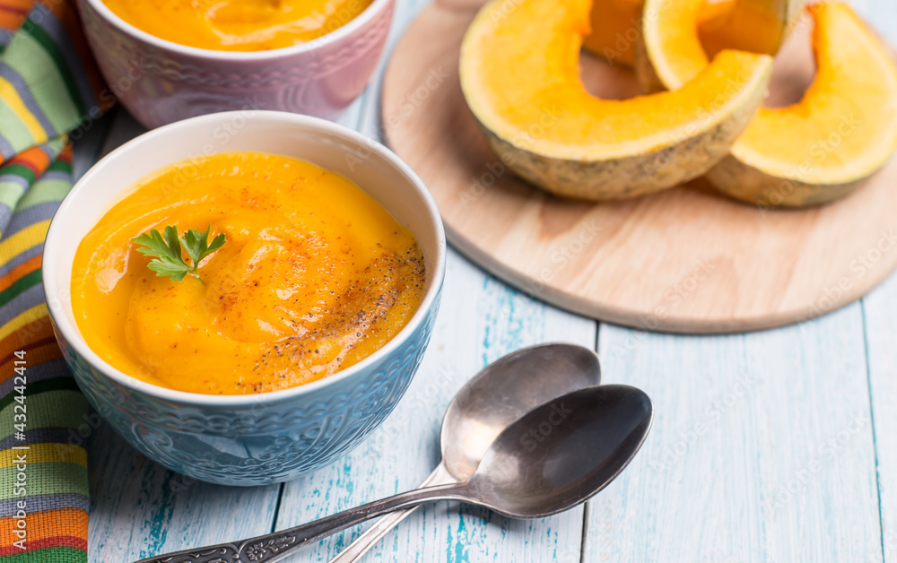 Traditional autumn pumpkin soup-puree on a blue background. Traditional autumn pumpkin soup-puree on a blue background.