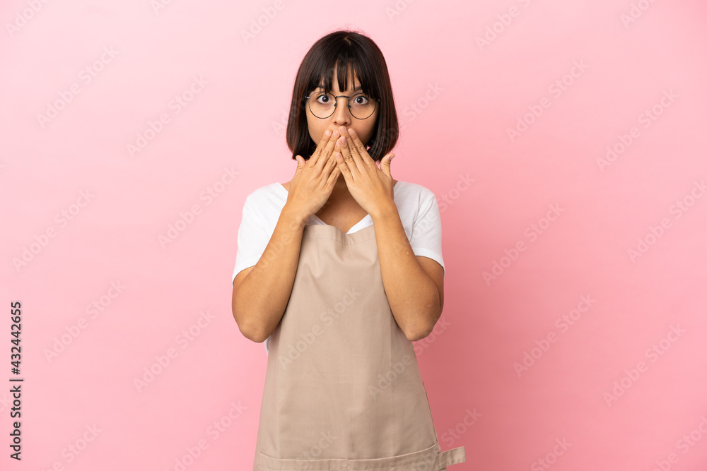 Restaurant waiter over isolated pink background covering mouth with hands Restaurant waiter over isolated pink background covering mouth with hands