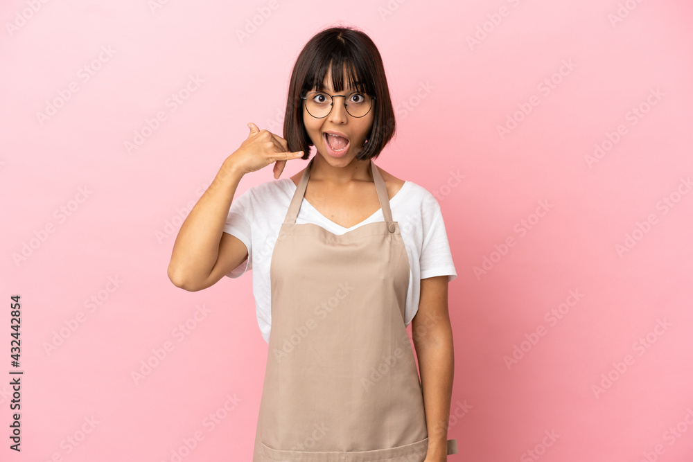 Restaurant waiter over isolated pink background making phone gesture. Call me back sign Restaurant waiter over isolated pink background making phone gesture. Call me back sign