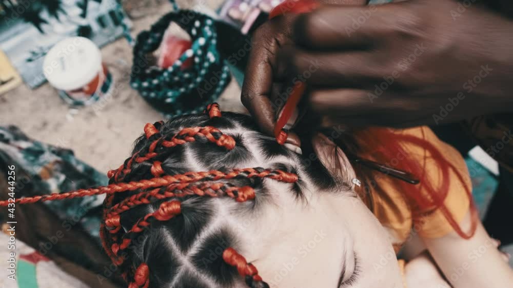 Vidéo Stock The process of weaving African braids with red kanekalon