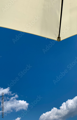 relaxing time in the sun under the parasol with a blue summer sky