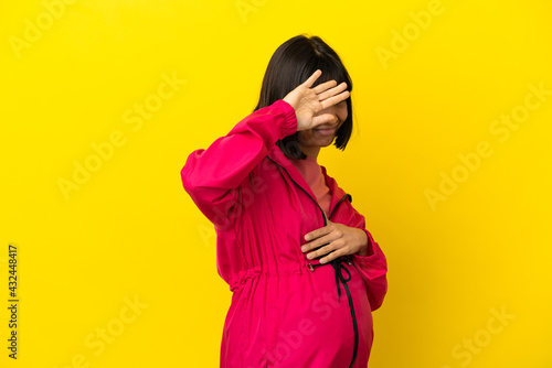 Young pregnant woman over isolated yellow background nervous stretching hands to the front © luismolinero