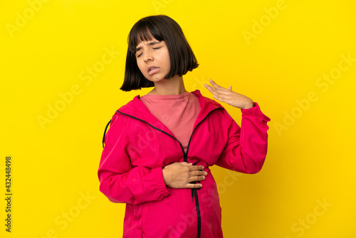 Young pregnant woman over isolated yellow background with tired and sick expression © luismolinero