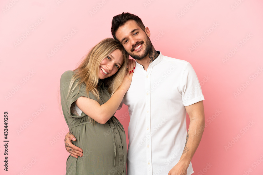 Pregnant woman and man over isolated pink background laughing Pregnant woman and man over isolated pink background laughing