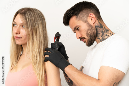 man tattooing a girl over isolated background