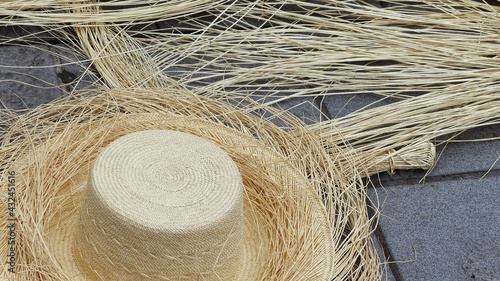 Ecuadorian handmade toquilla straw hat (panama hat), not finished, and straw used to make it on concrete background. Popular souvenir from South America, Cuenca photo