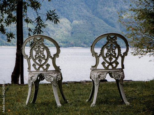 Two chairs looking to a lake and mountains behind. Caburgua, Chile. photo