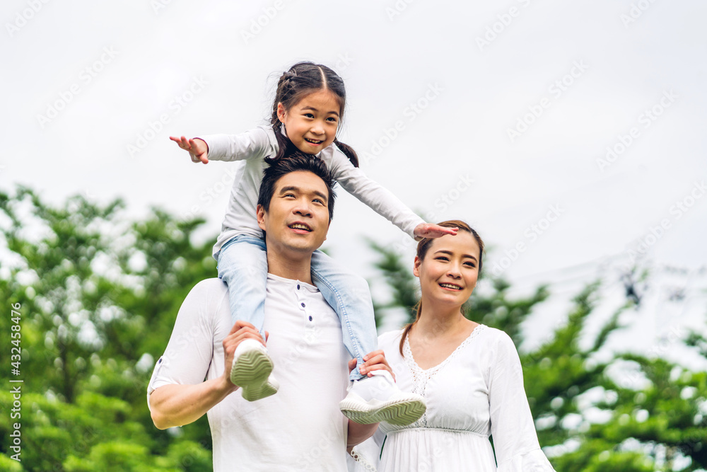 Portrait of enjoy happy love asian family father and mother holding cute little asian girl child smiling playing and having fun moments good time in summer park at home Portrait of enjoy happy love asian family father and mother holding cute little asian girl child smiling playing and having fun moments good time in summer park at home