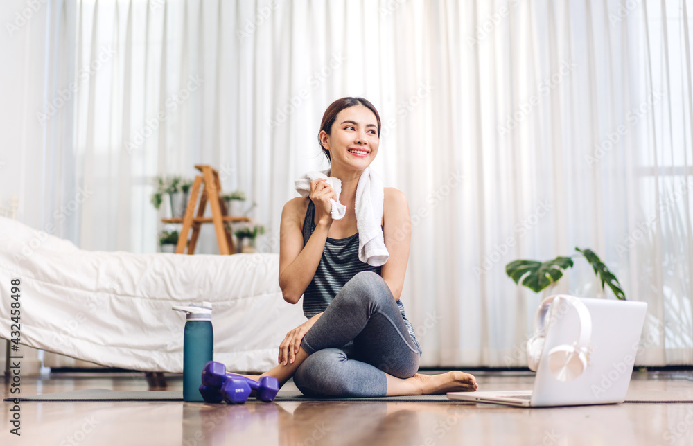 Portrait of sport asian beauty body slim woman in sportswear sitting relax and practicing yoga and do fitness exercise with laptop computer in bedroom at home.Diet concept.Fitness and healthy Portrait of sport asian beauty body slim woman in sportswear sitting relax and practicing yoga and do fitness exercise with laptop computer in bedroom at home.Diet concept.Fitness and healthy