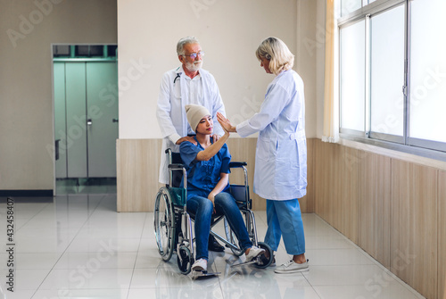 Professional medical doctor team with stethoscope in uniform discussing with patient woman with cancer cover head with headscarf of chemotherapy cancer in hospital.health care concept