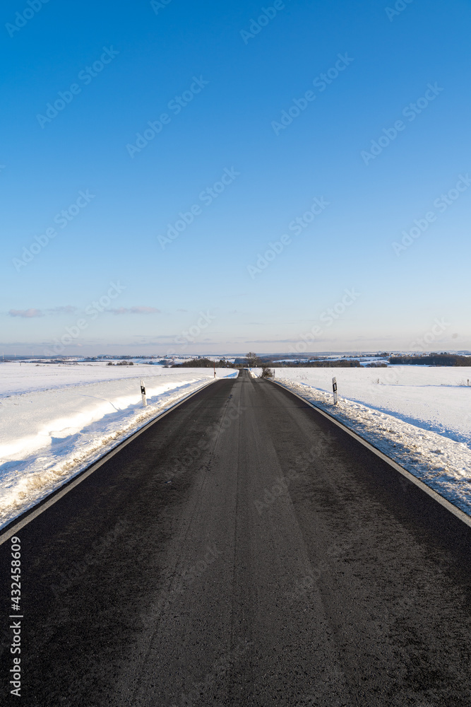 Beautiful road between snow with nice blue sky Beautiful road between snow with nice blue sky