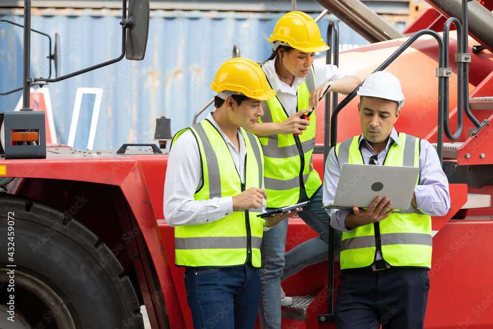 factory workers or engineers using laptop computer and talking about project work beside truck in containers warehouse storage factory workers or engineers using laptop computer and talking about project work beside truck in containers warehouse storage