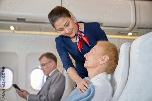 Air hostess girl take care with grand ma old woman in flight travel on aircraft cabin © bank215