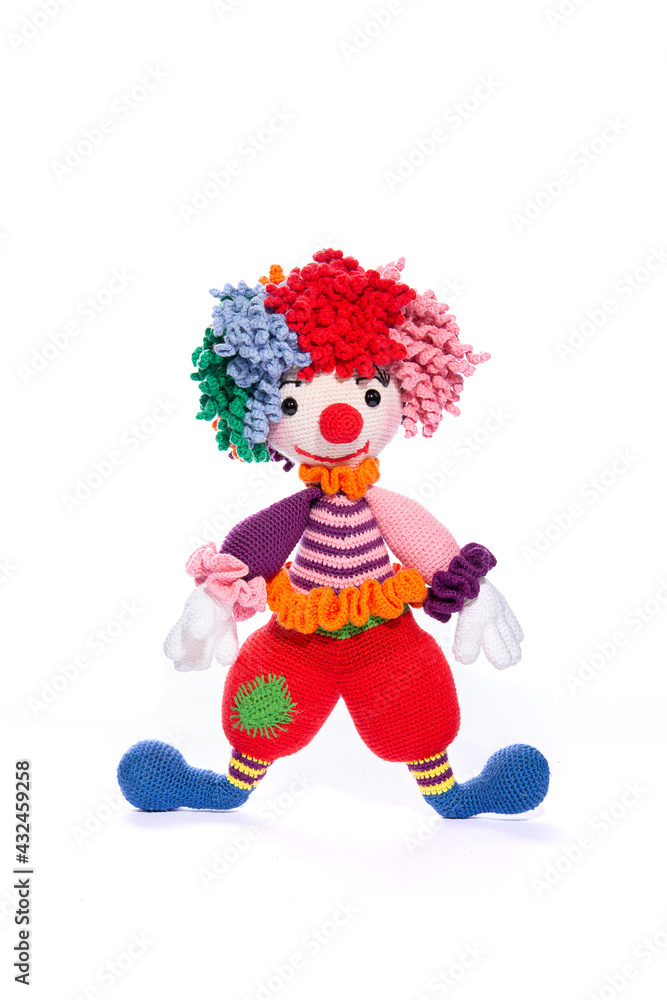Amigurumi doll is a colorful clown standing on a white background Amigurumi doll is a colorful clown standing on a white background