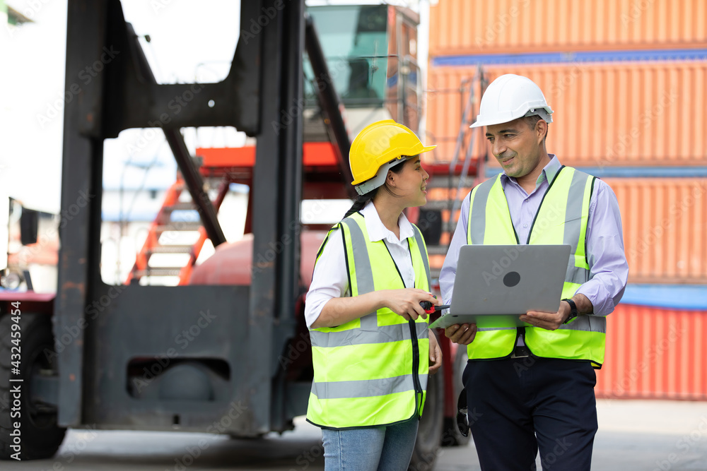 factory workers or engineers using laptop computer and talking about project work in containers warehouse storage factory workers or engineers using laptop computer and talking about project work in containers warehouse storage