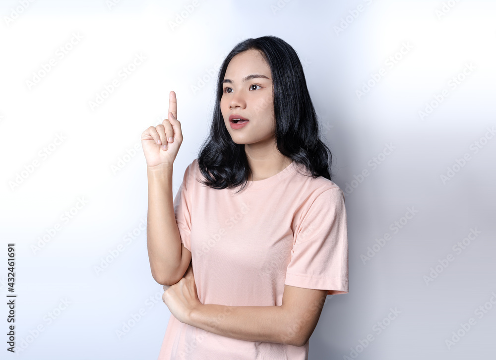 Girl has an idea to solve problem. Pretty Asian woman keeping finger pointed upwards. Young female raising index finger in eureka gesture, discussing new concept and solutions, solutions sign concept Girl has an idea to solve problem. Pretty Asian woman keeping finger pointed upwards. Young female raising index finger in eureka gesture, discussing new concept and solutions, solutions sign concept
