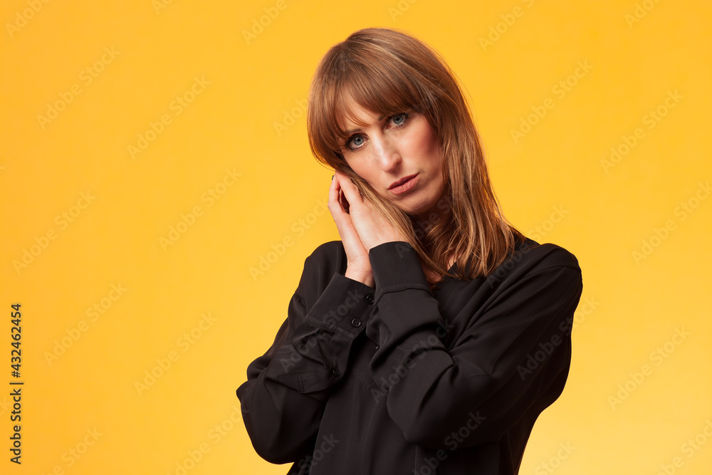Portrait of an attractive woman wearing a black long sleeve blouse against a yellow background
Portrait of an attractive woman wearing a black long sleeve blouse against a yellow background