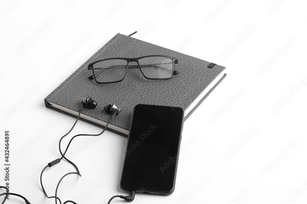 work from home concept. smartphone, diary and earphone on white background work from home concept. smartphone, diary and earphone on white background