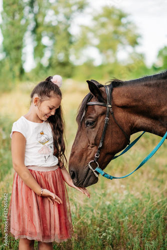 Emotional contact with the horse. Horse riding. The girl rides a horse in the summer.