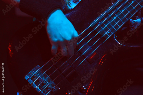 The bass player plays a five-string bass guitar