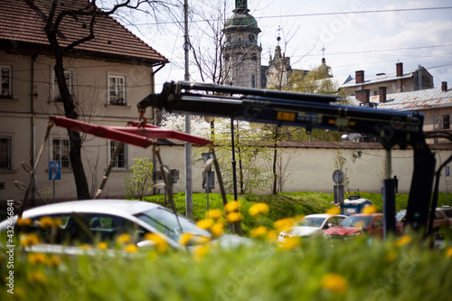 Tow truck in the old city of Lviv against the backdrop of the Bernardine Cathedral and dandelions