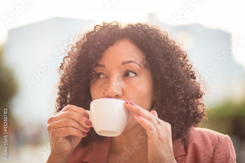  Portrait of woman drinking coffee on the street.