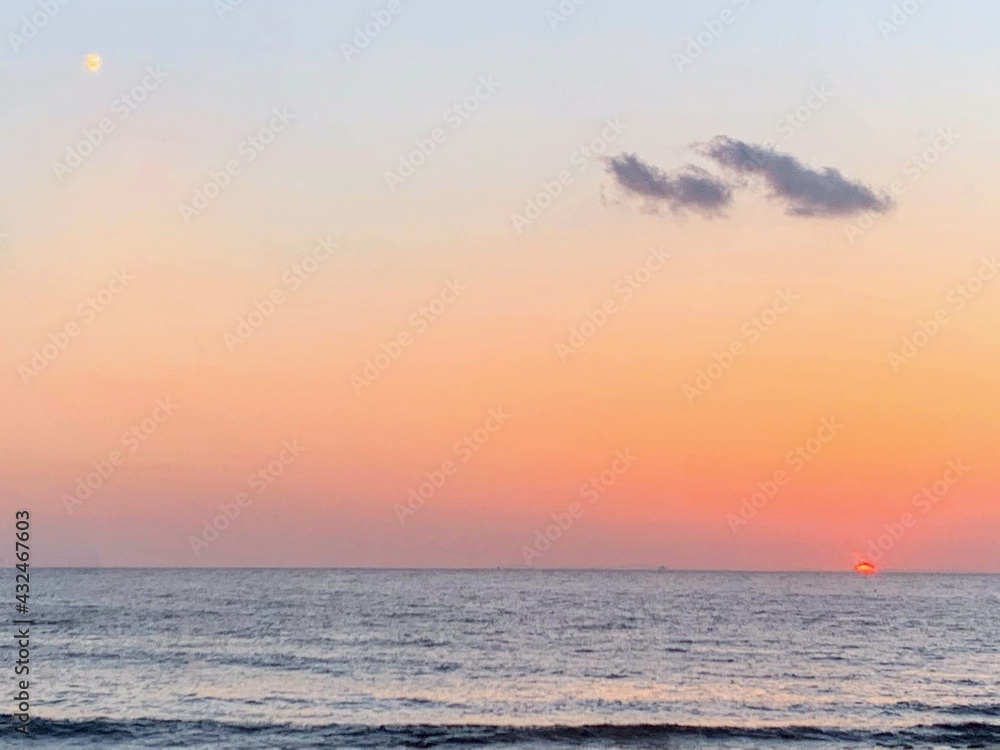 Beautiful scenery of the setting sun over the calm sea Beautiful scenery of the setting sun over the calm sea
