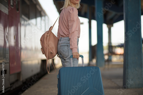  Young woman with suitcase going on vacation.