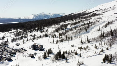 Sunny winter spring skiing day in Sweden. Swedish ski slopes from above in aerial drone shot. Cable lifts running and people riding downhill photo