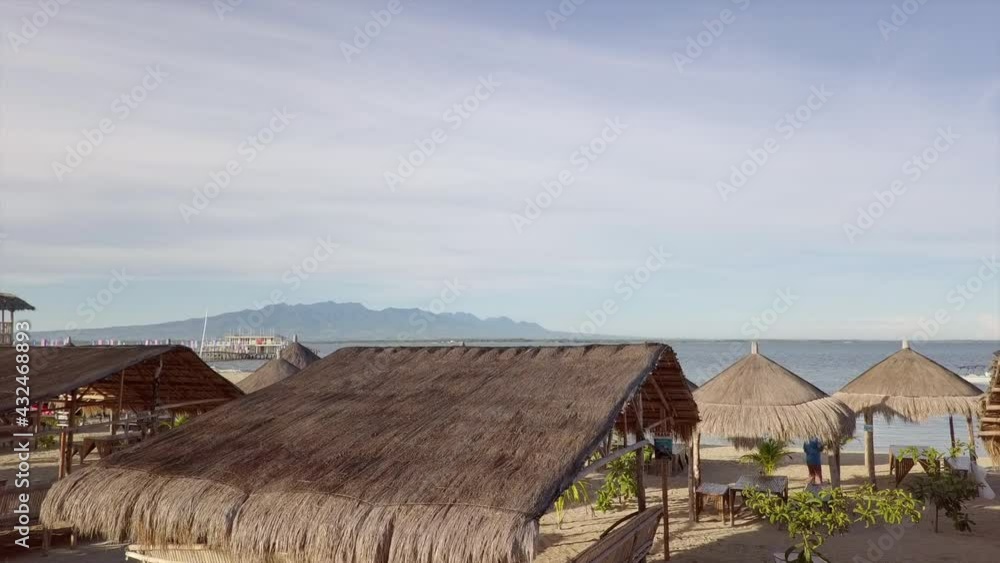 Aerial Shot Of Thatched Roof Huts And Parasols At Beach In Summer, Drone Flying Forward - Lakawon, Philippines Aerial Shot Of Thatched Roof Huts And Parasols At Beach In Summer, Drone Flying Forward - Lakawon, Philippines