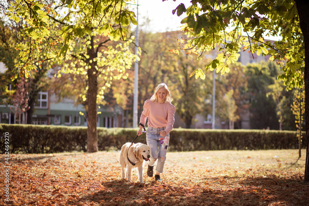 Woman running with dog in the park. Woman running with dog in the park.