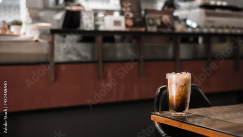 Close-up of iced coffee served on black table at cafe​