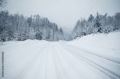 Landscape view of road surrounded with forest covered with fresh snow. Daylight, winter motif in Gorski Kotar, Croatia.