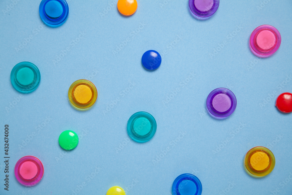 Colorful magnet plastic buttons on blue background. Colorful magnet plastic buttons on blue background.