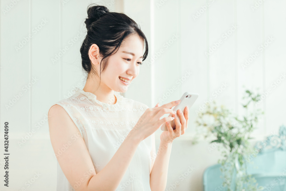 スマホを見る女性(笑顔)
スマホを見る女性(笑顔)