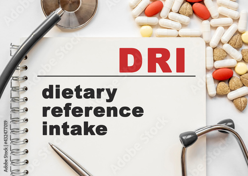 Page in notebook with DRI on white background with stethoscope and group of pill. Medical concept. Term and abbreviation. dietary reference intake photo