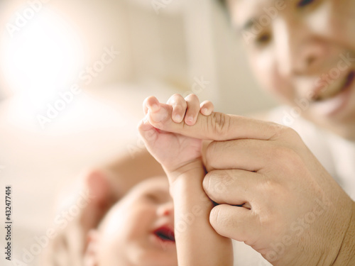  Baby hand holding finger of her Dad , Father's day or happy family concept