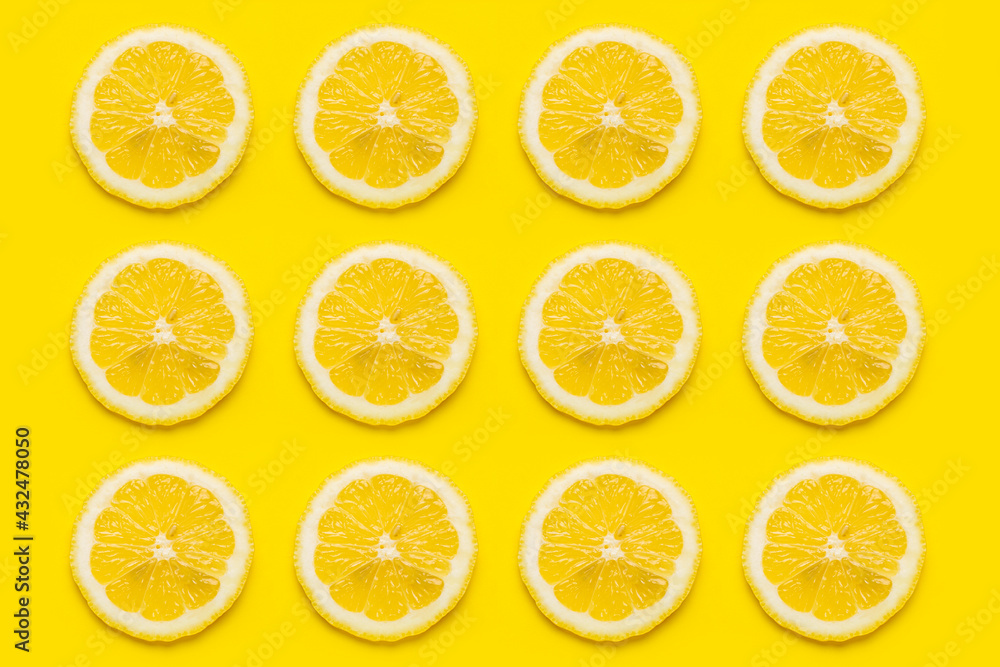 background of ripe lemon slices against on a yellow background. Top view, flat lay